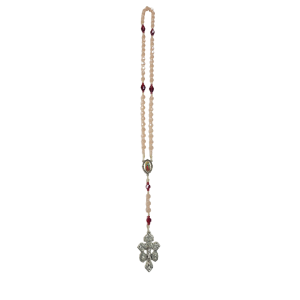 A necklace featuring pink beads and red accents, with a central medallion and an ornate silver cross pendant, suggesting elegance and spirituality.